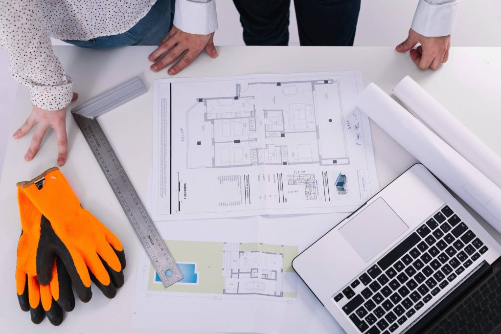 Construction team reviewing MEP blueprints and project planning documents